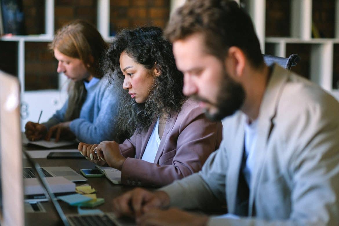 Serious colleagues working with laptops in office