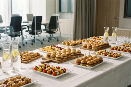 Table de buffet d'entreprise élégante avec assortiment de finger foods, sandwiches et plateaux de fruits dans une salle de réunion moderne