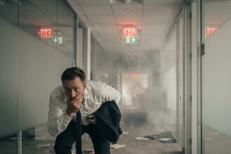 Employé de bureau évacuant un couloir enfumé lors d'un incendie dans un immeuble de bureaux