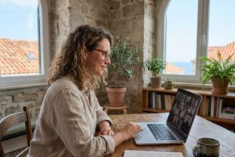 Freelance travaillant en visioconférence depuis un espace de coworking à Marseille avec vue sur les toits méditerranéens