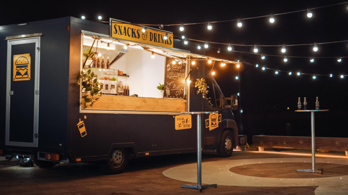Un food truck avec un panneau jaune indiquant des collations et des dates
